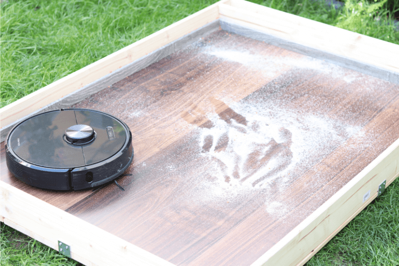 Roborock S6 в испытательной зоне удаляет песок с твердого пола.